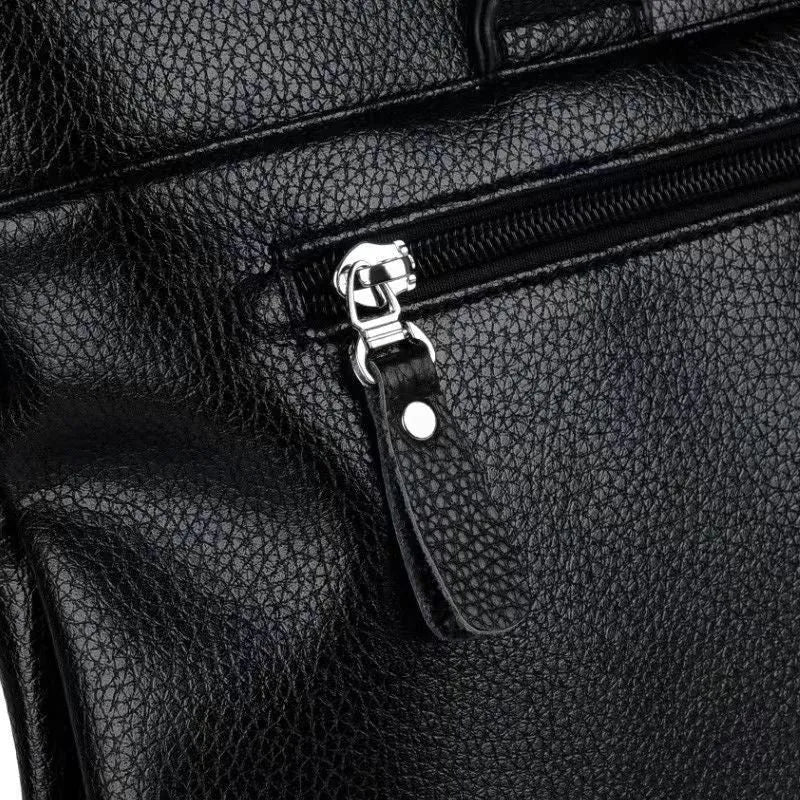 Men's black PU leather business messenger bag with spliced design shown from the side.