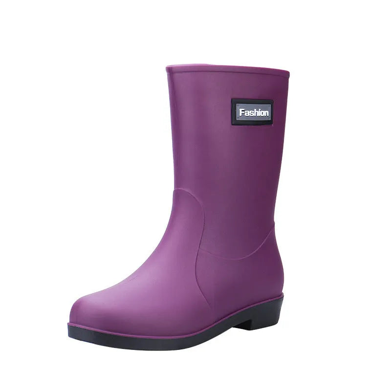 Women's mid-calf PVC rain boot in black on a wet surface