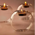 Clear hollow glass spherical candle holder in European style on a table.