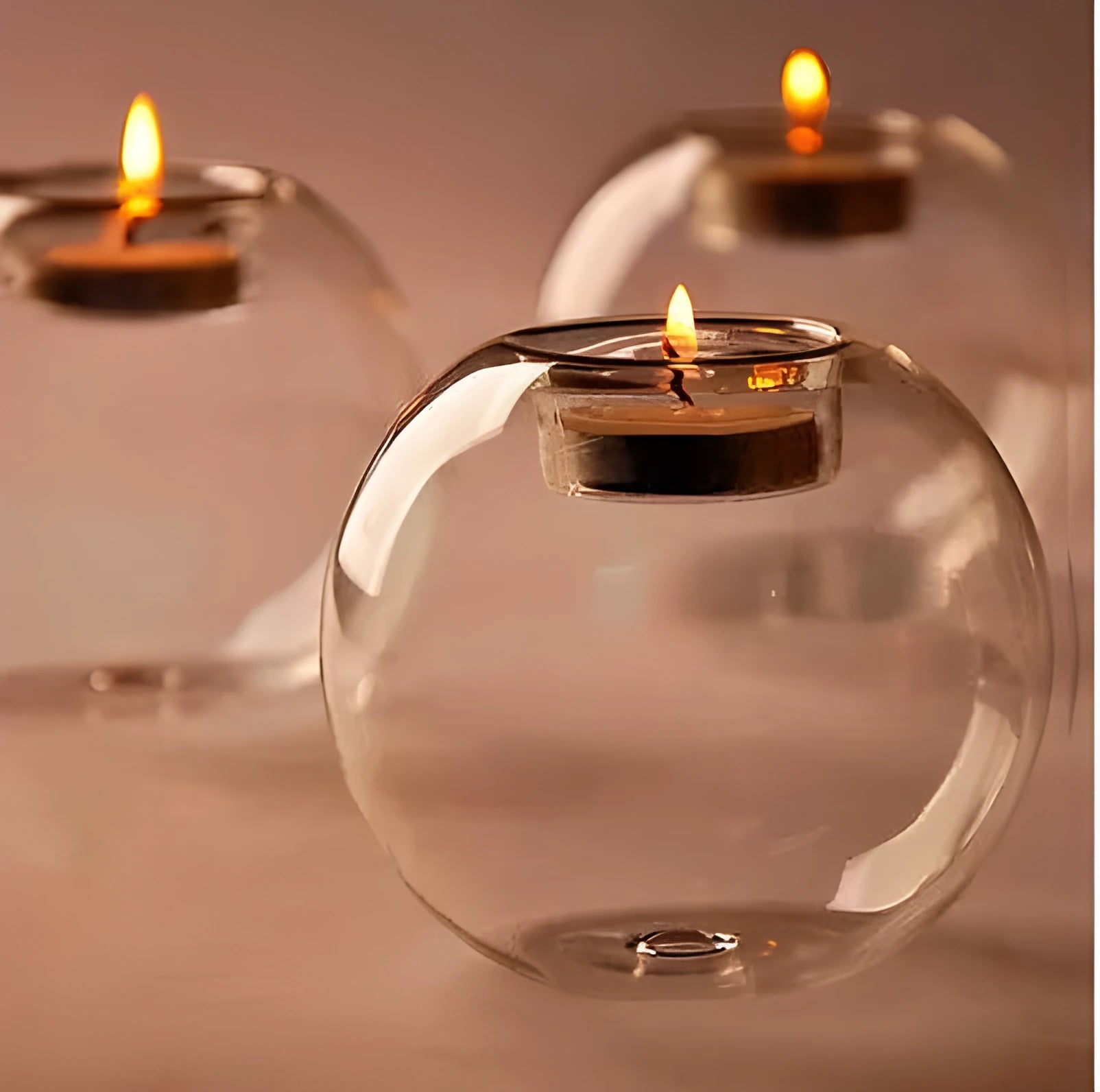 Clear hollow glass spherical candle holder in European style on a table.
