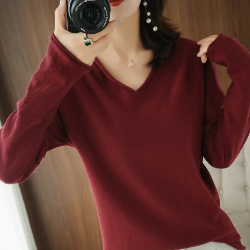 Women's turmeric V-neck long sleeve knitwear top laid flat.