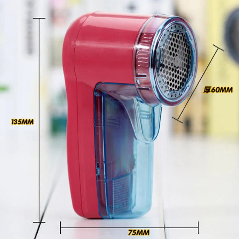 Portable electric clothing lint remover shaver in hand, showing compact size and shaving head.