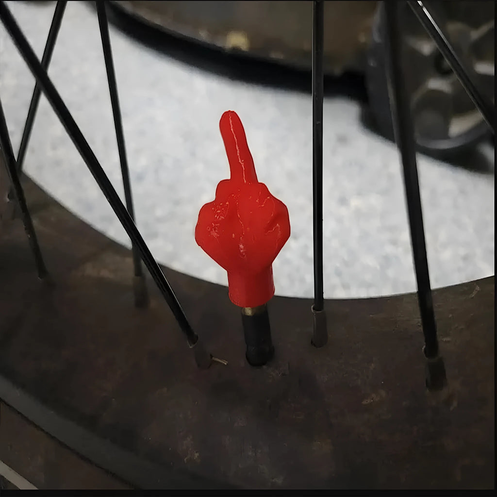 Four latex tyre valve caps, two black and two skin tone, on a grey background