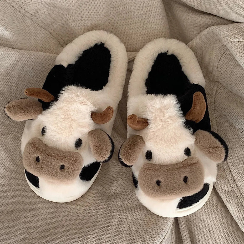 White and coffee coloured cow-themed plush slippers for women with a textured non-slip sole.