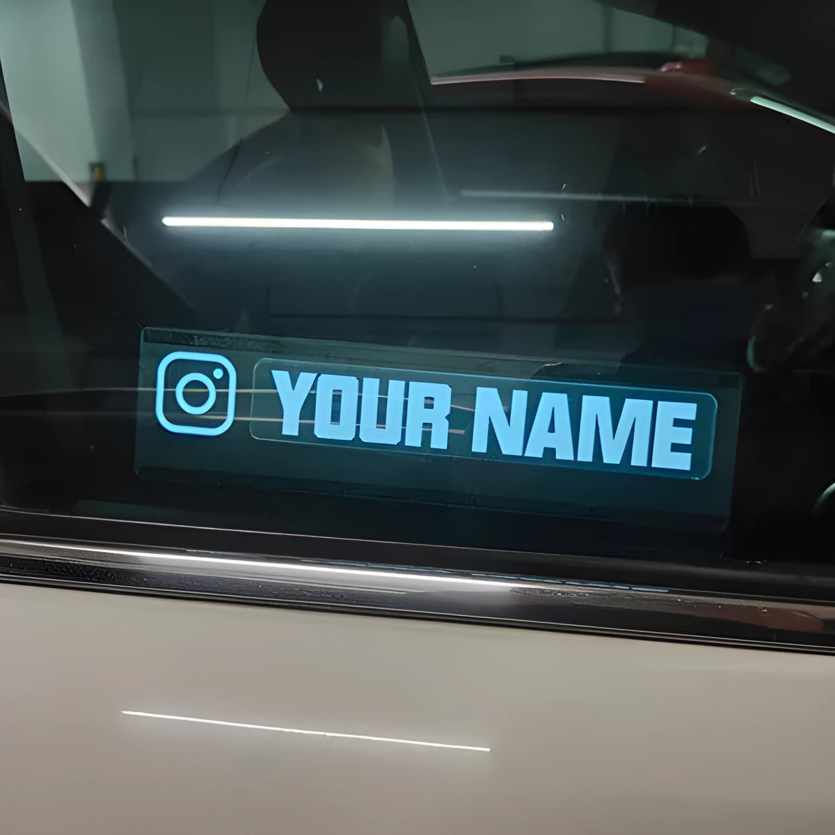 White glowing illuminated car window sticker with driver and cable on a vehicle.