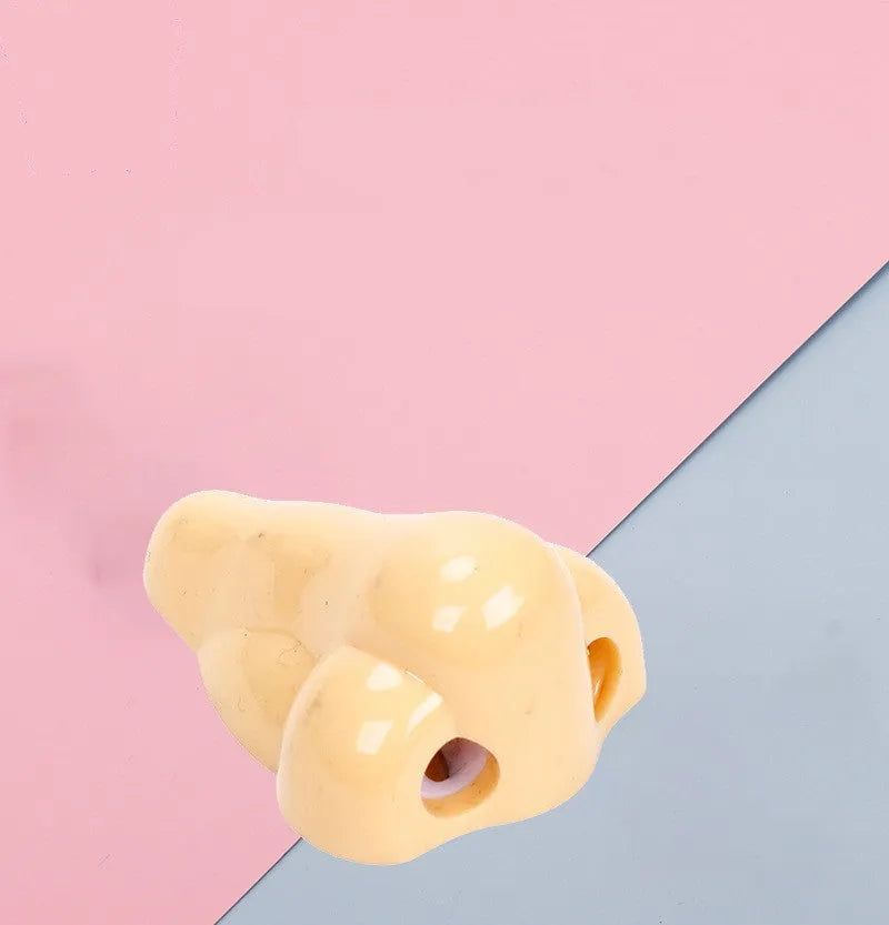 Flesh coloured plastic manual pencil sharpener with a geometry shape and large nostril opening.