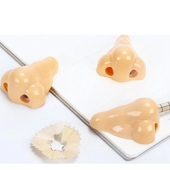 Flesh coloured plastic manual pencil sharpener with a geometry shape and large nostril opening.