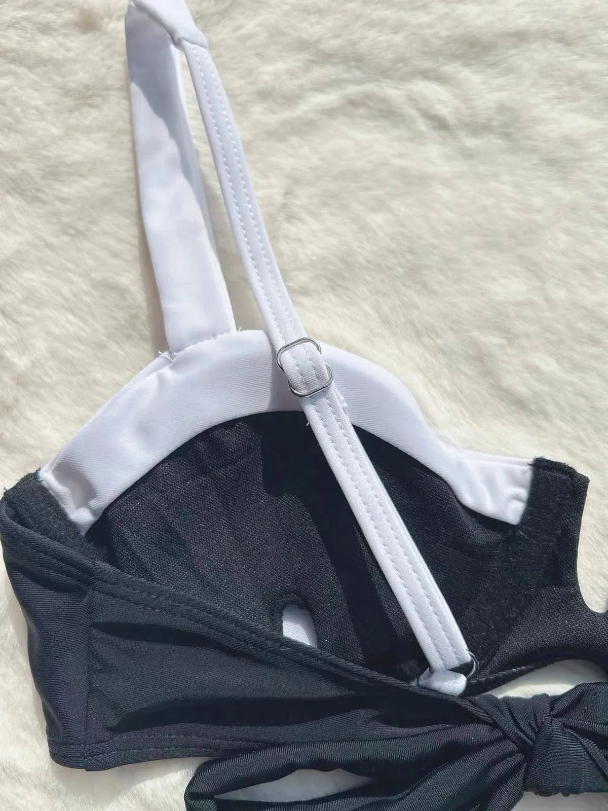Black low waist women's bikini swimsuit with stitching split detail on a mannequin.