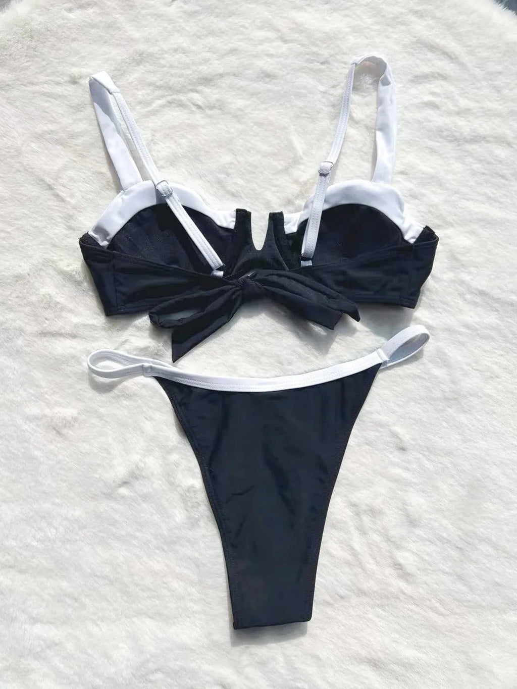 Black low waist women's bikini swimsuit with stitching split detail on a mannequin.