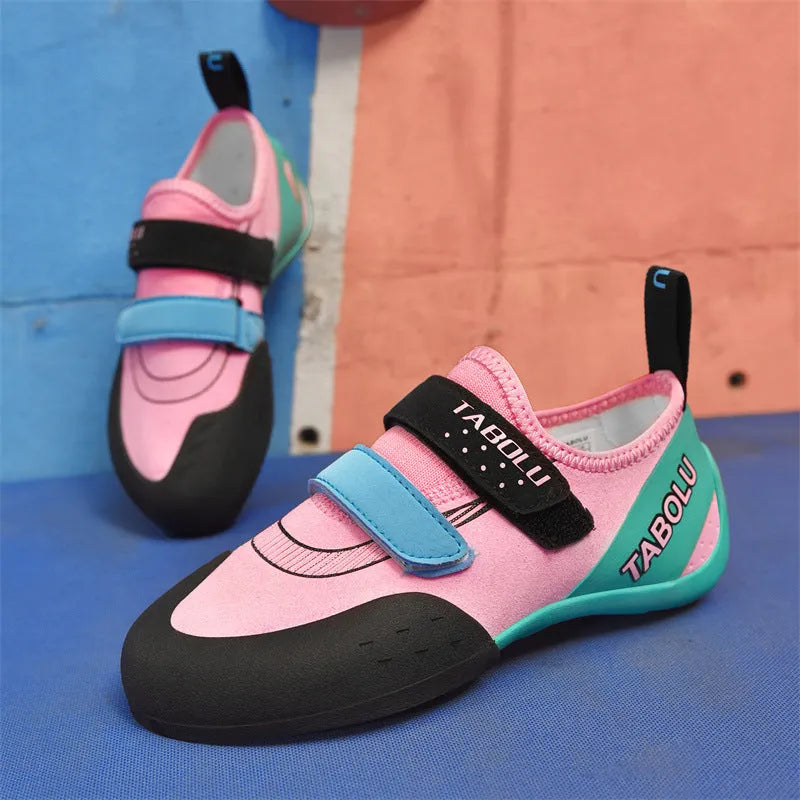Beginner rock climbing shoes in black and red with Velcro strap and rubber sole.