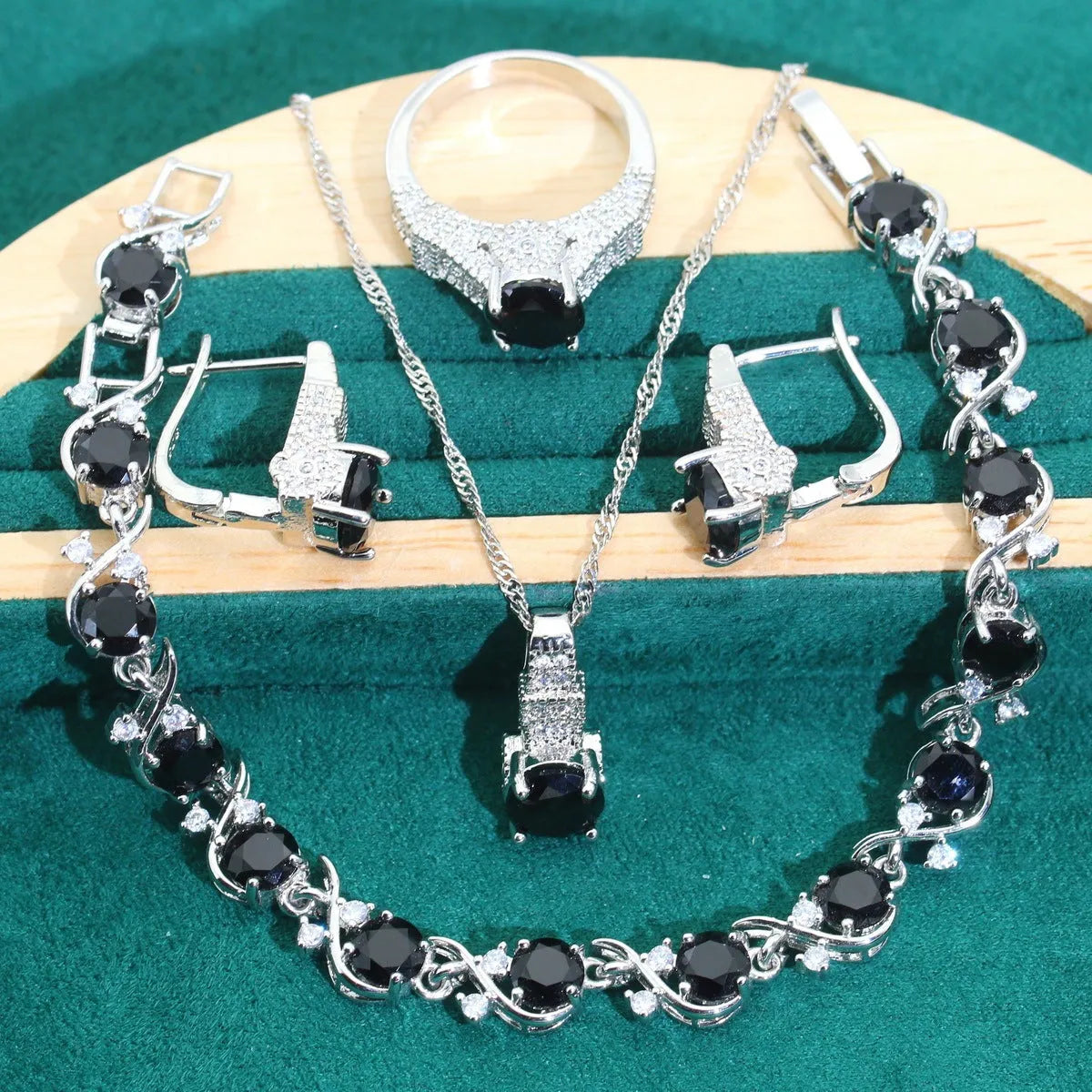 Four-piece bridal jewellery set showing alloy pendant necklace, bracelet, earrings, and ring on a white background.