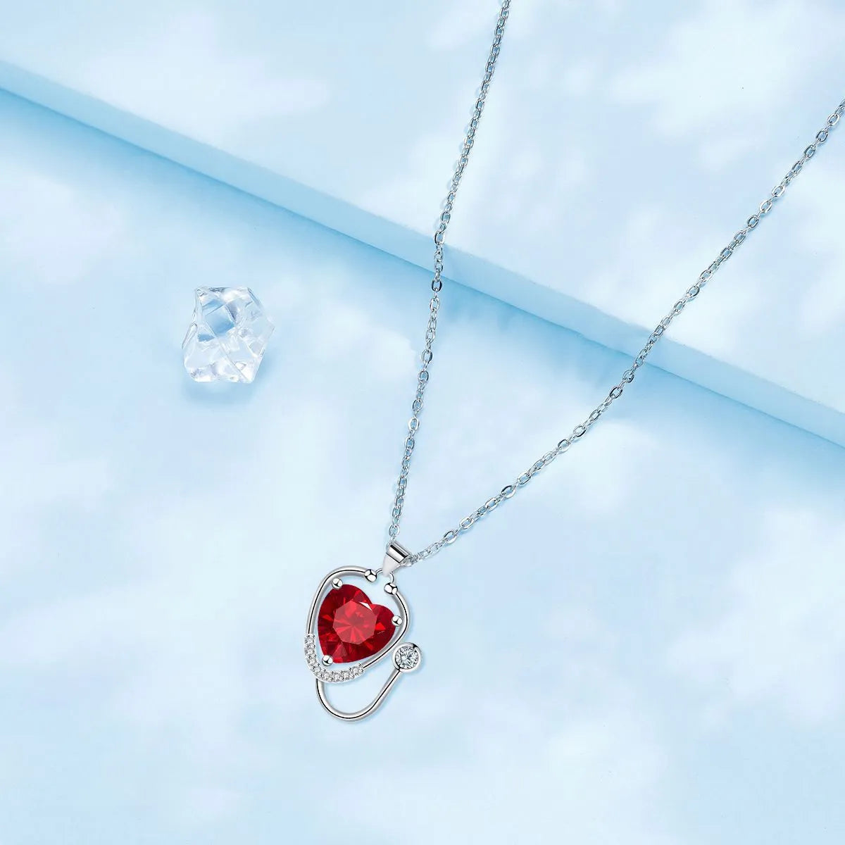 Red diamond coloured women's necklace with stethoscope, wings and cross pendant design