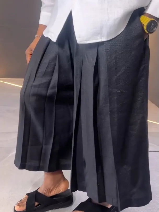 White asymmetric long sleeve shirt paired with black pleated pants in casual two-piece set