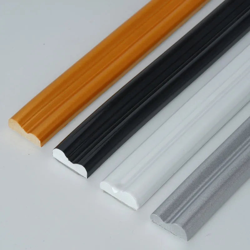 Flexible PVC self-adhesive backdrop edge trim in black, gold, silver, and white on a white surface
