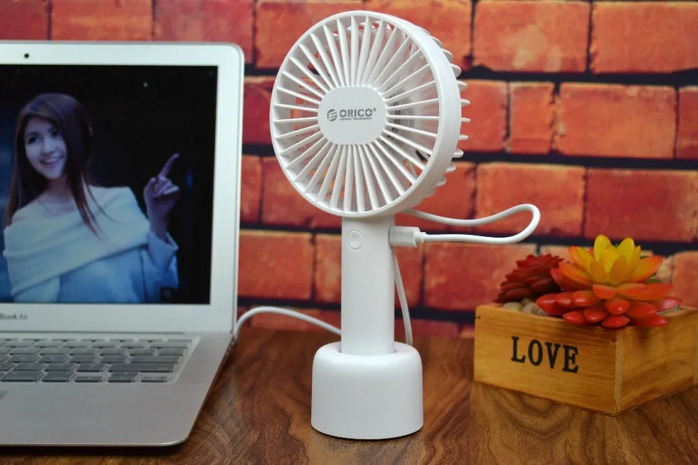 ORICO FH1 white portable USB rechargeable fan with three-speed settings on a desk.