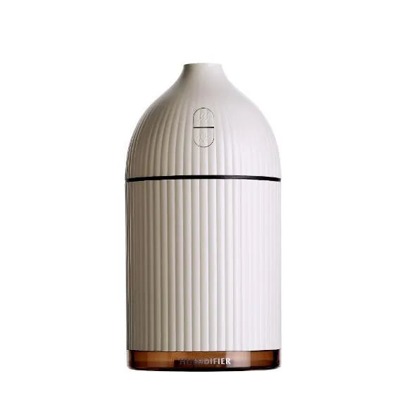 White ultrasonic aromatherapy diffuser humidifier with USB cable and LED light on wooden table