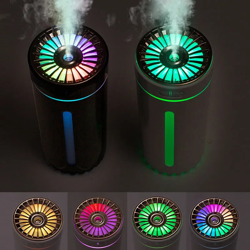 Black wireless ultrasonic humidifier with colourful lights, shown next to a USB cable on a desk.