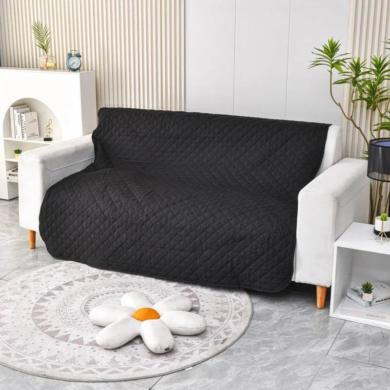 Waterproof reversible dog blanket on sofa showing two colour sides, protecting furniture from pet stains and hair