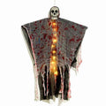 Halloween decoration showing a luminous blood-dyed plastic skull with a hanging ghost outdoor ornament