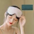 Green portable eye SPA mask with USB cable on a grey background