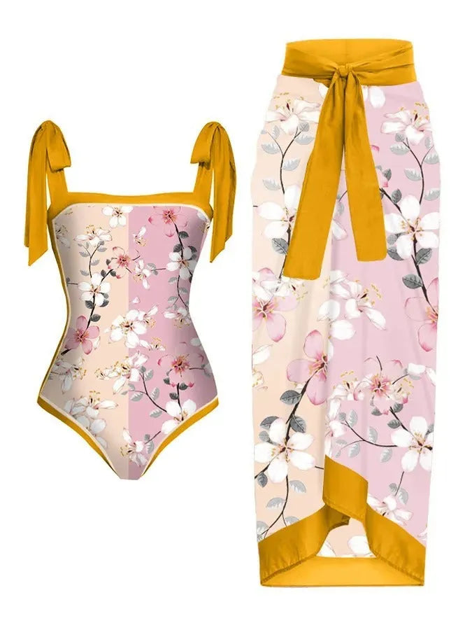 Women's floral print two-piece swimsuit with a sheer black chiffon hip skirt overlay.