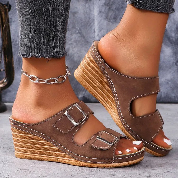 Women's creamy-white beach slippers with a wedge heel and an adjustable buckle strap across the foot.