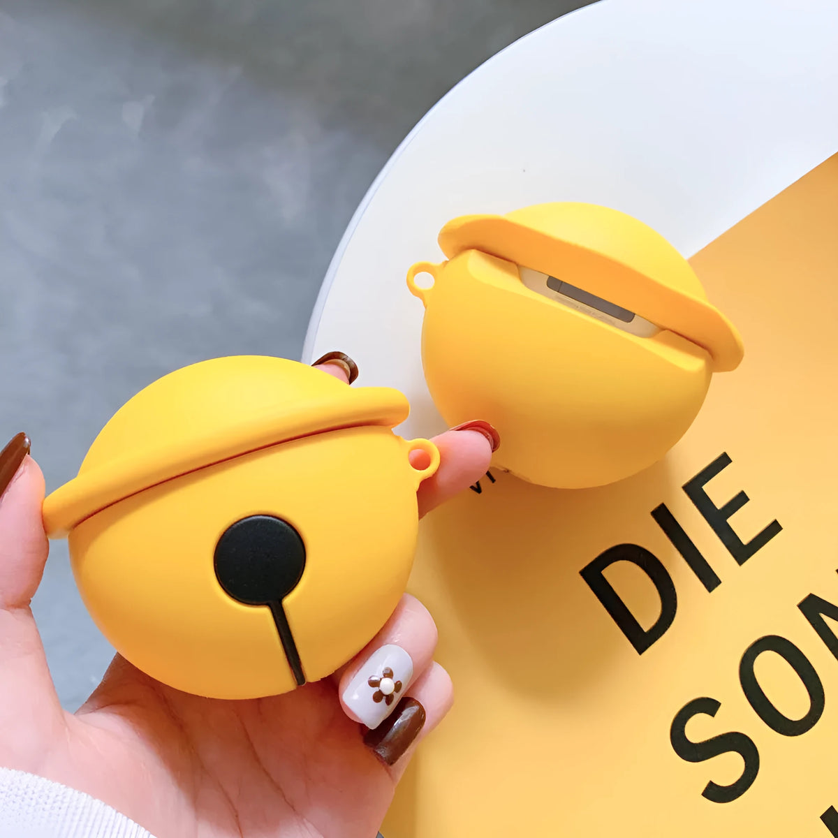 Yellow silicone AirPods case with attached bell for 1st and 2nd generation charging cases