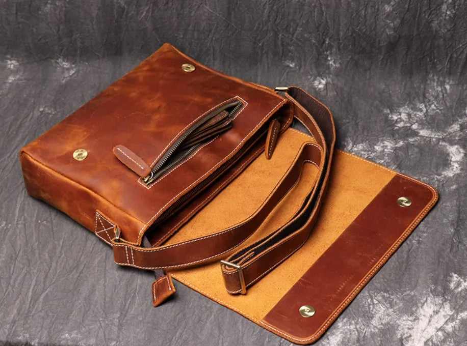 Vintage brown leather mens messenger bag with a flap opening and adjustable shoulder strap.