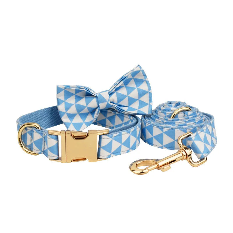 Blue cloth dog collar, leash, vest, and bow set arranged together showing all four pieces.