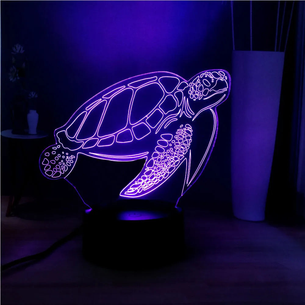 3D clear acrylic turtle-shaped LED night light with multi-colour glow on a surface.