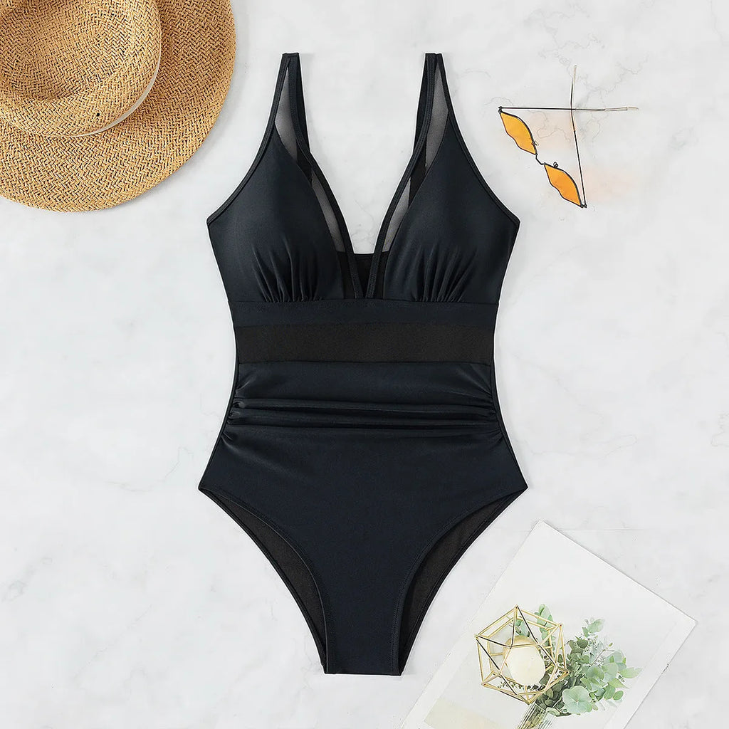 Black women's one-piece halter swimsuit with mesh detailing and attached briefs, shown on a size chart.