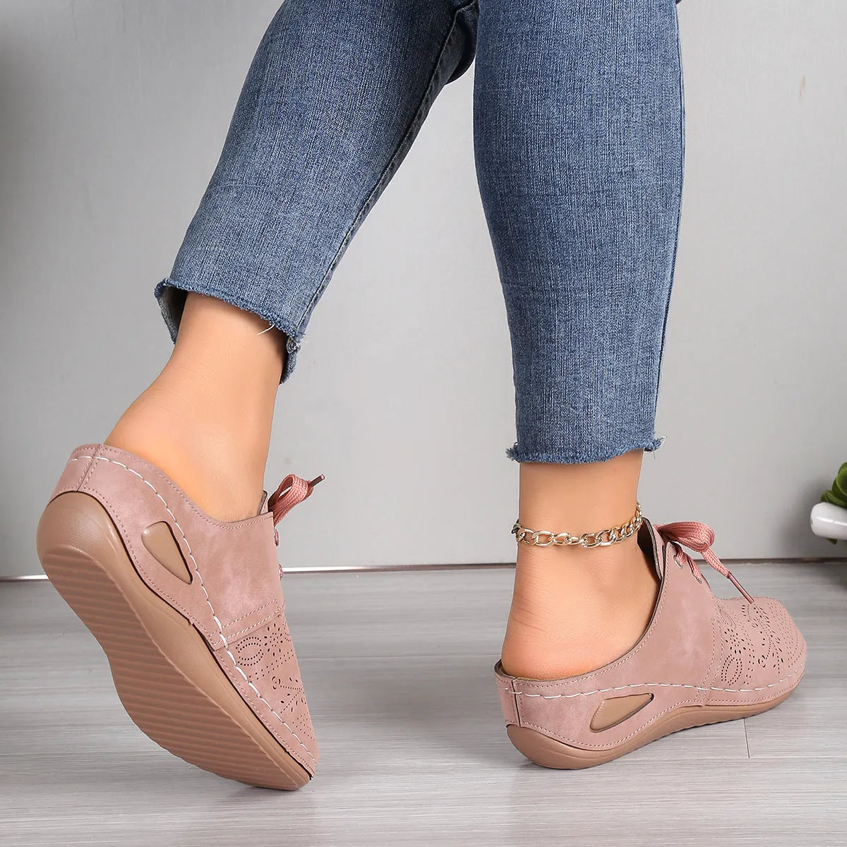 Women's black lace-up baotou slippers with a suede upper and rubber sole on a neutral background.