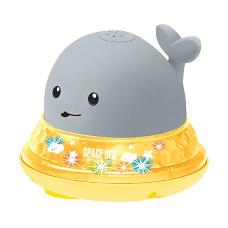 Whale-shaped electric bath toy spraying water with coloured LED lights, shown with base unit on blue background