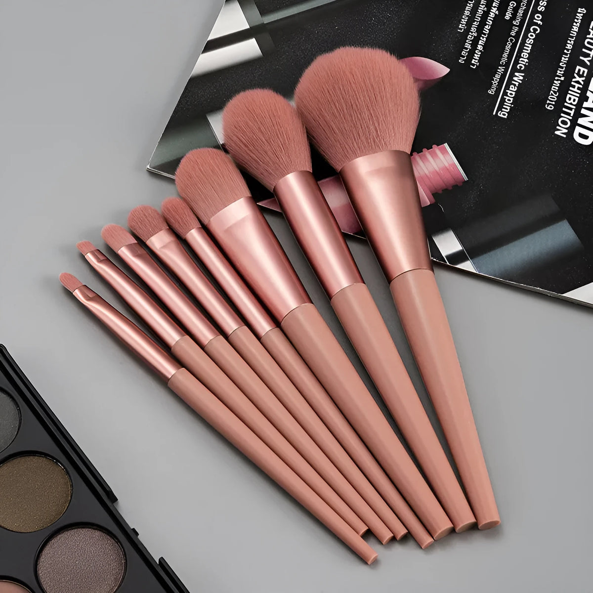 8-piece pink makeup brush set with man-made fibre heads and portable plastic handles, no bag included