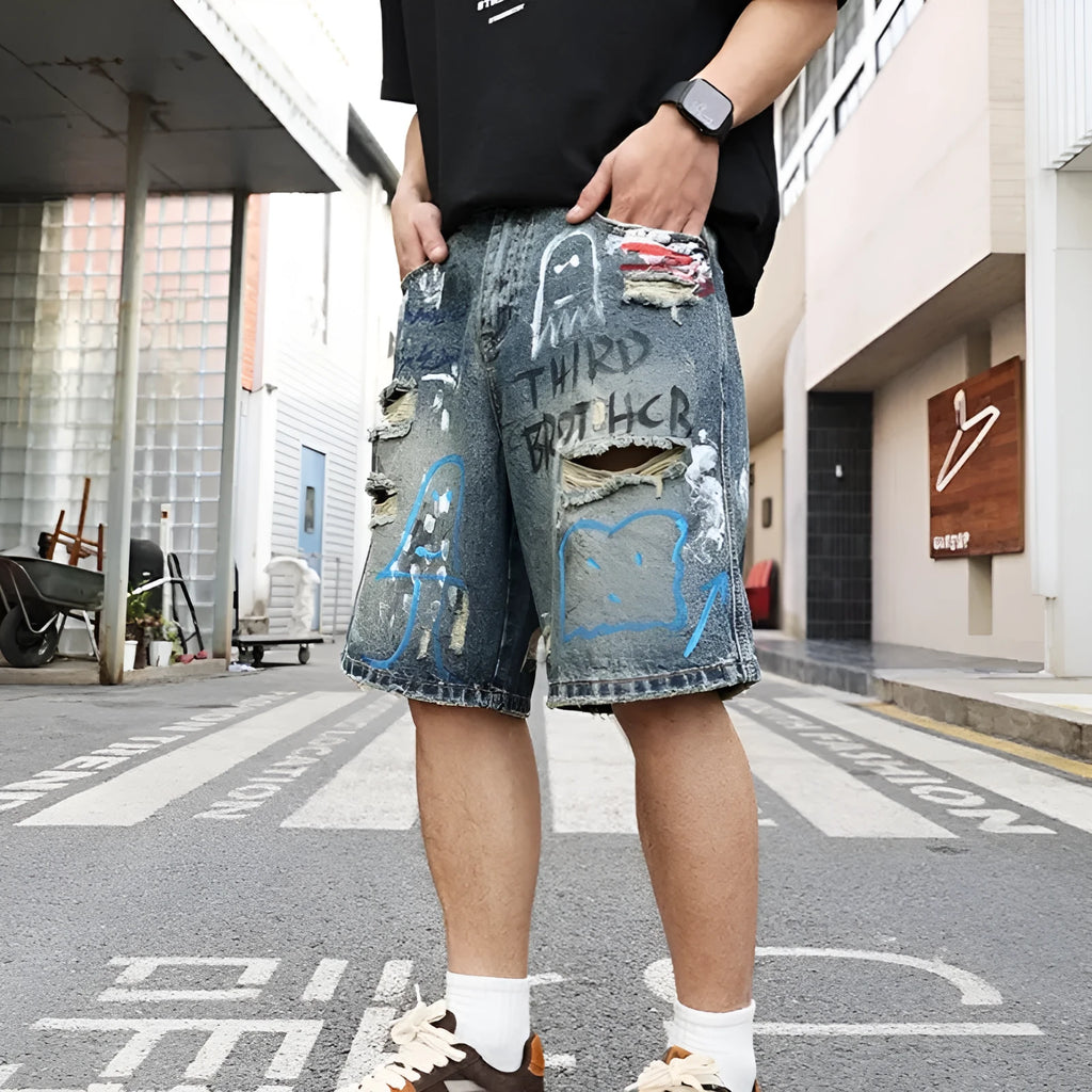 Blue men's ripped denim shorts with a straight leg cut and zip fly front.
