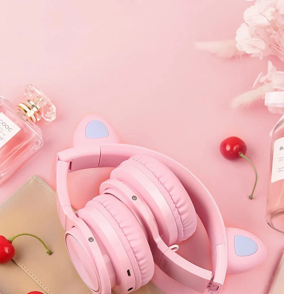 Pink and white wireless Bluetooth over-ear headphones with protein ear cushions and braided charging cable