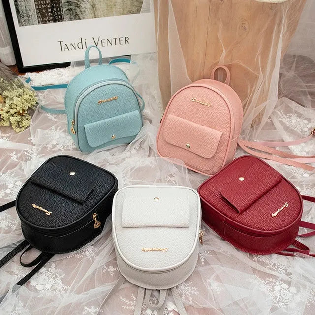 Women's small PU leather backpack shoulder bag in black showing front zipper and compact size