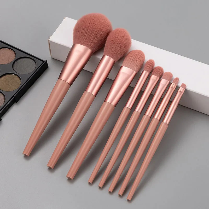8-piece pink makeup brush set with man-made fibre heads and portable plastic handles, no bag included