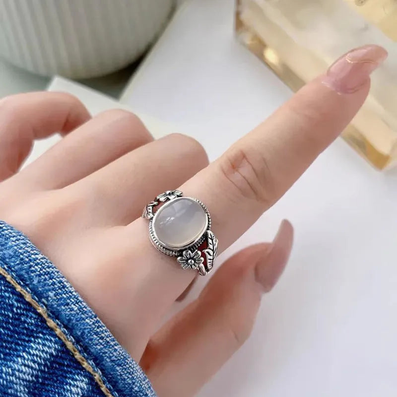 Antiqued copper ring with white stone and adjustable U-shaped opening.