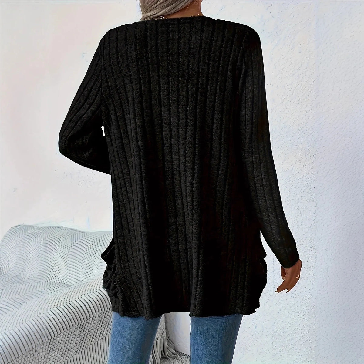 Loose fit grey cardigan with long sleeves and side pockets on a hanger.