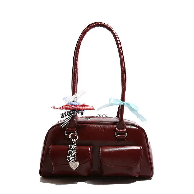 Brown retro-style women's PU leather pillow bag with flap and double strap, shown with ribbon pendant.
