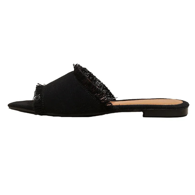 Women's flat denim slippers with tassel detail in apricot colour on a white background.