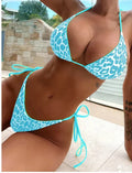 Women's lace-up front triangle bikini top with matching split skirt swim shorts.