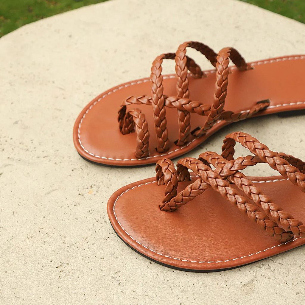 Women's woven clip-toe flat sandals in white, shown on a foot.
