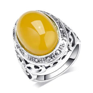 Geometric retro-style alloy ring in antique silver amber colour on a finger.