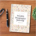A5 pregnancy weekly diary notebook open showing weekly formatting pages