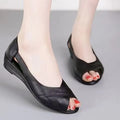Women's black peep toe sandals with a mid heel and ankle buckle strap on a rubber sole.