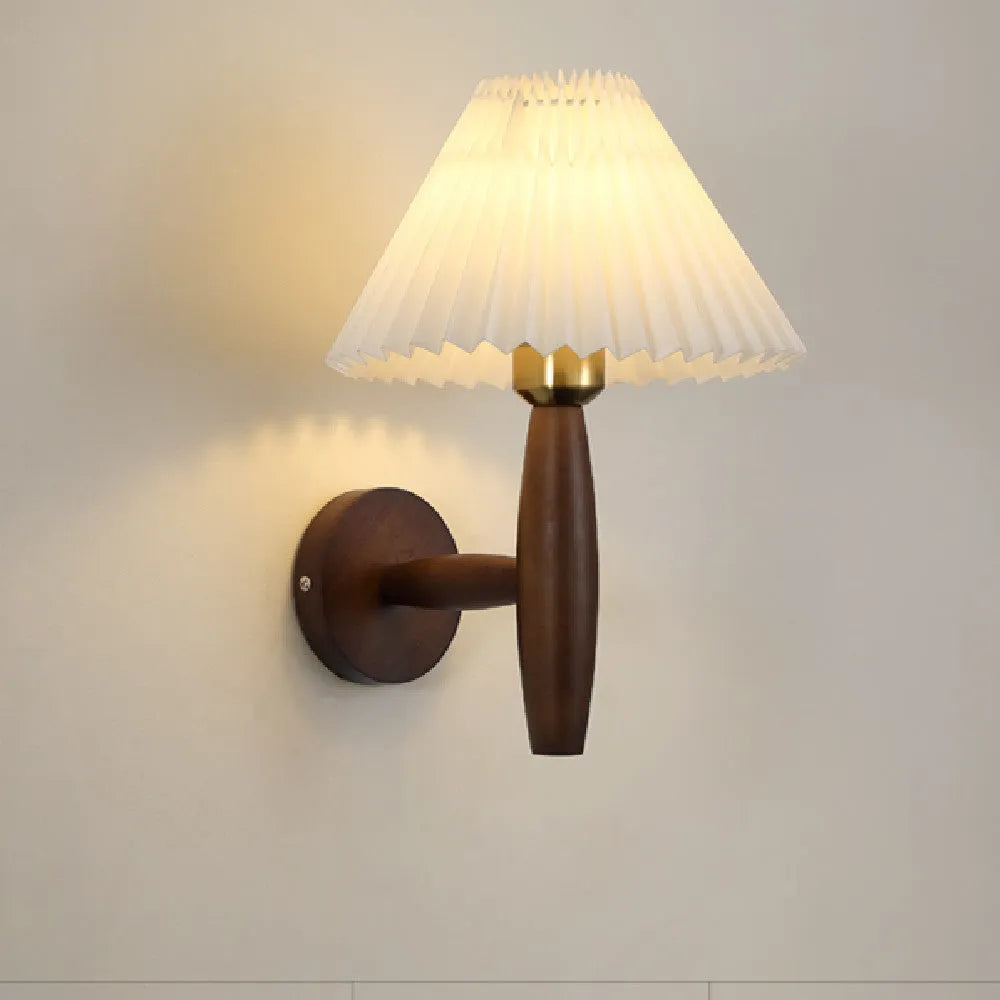 American Retro style wooden wall lamp with copper accents and a white fabric shade mounted above a bedside table.