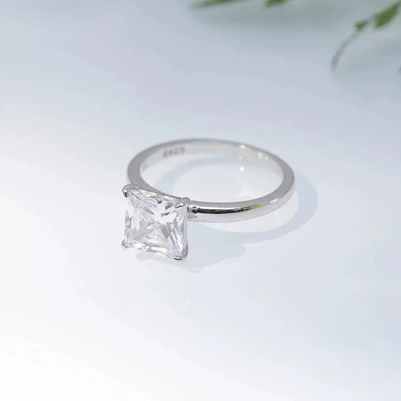 Simple geometric sterling silver ring with round stone on a woman's hand, shown in silver, gold, and rose gold colours.
