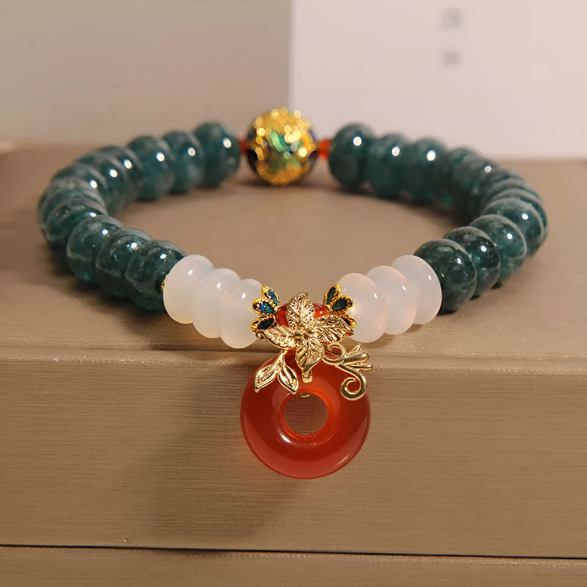 Women's blue water jade and red agate bracelet with peace buckle closure and rhinestone details